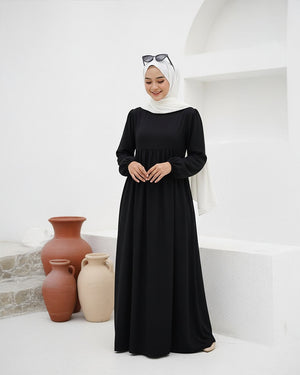 مودل ترتدي فستان طويل مودست باللون اسود من ضي Dhai، تصميم واسع ومحتشم بأكمام طويلة مع حجاب مطابق، إطلالة أنيقة وبسيطة على خلفية بيضاء.
فستان برجاندي 
مودست فاشون
دريس ميلتون
دريس ملتون