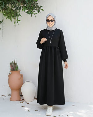 مودل ترتدي فستان طويل مودست باللون اسود من ضي Dhai، تصميم واسع ومحتشم بأكمام طويلة مع حجاب مطابق، إطلالة أنيقة وبسيطة على خلفية بيضاء.
فستان برجاندي 
مودست فاشون
دريس ميلتون
دريس ملتون