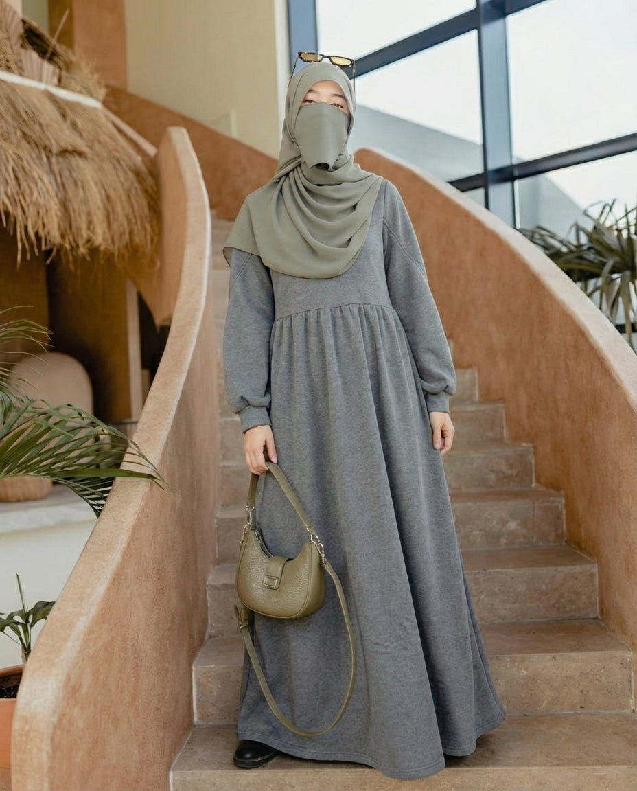 مودل ترتدي فستان طويل مودست باللون الفضي او الجراي من ضي Dhai، تصميم واسع ومحتشم بأكمام طويلة مع حجاب مطابق، إطلالة أنيقة وبسيطة على خلفية بيضاء.
فستان برجاندي 
مودست فاشون
دريس ميلتون
دريس ملتون