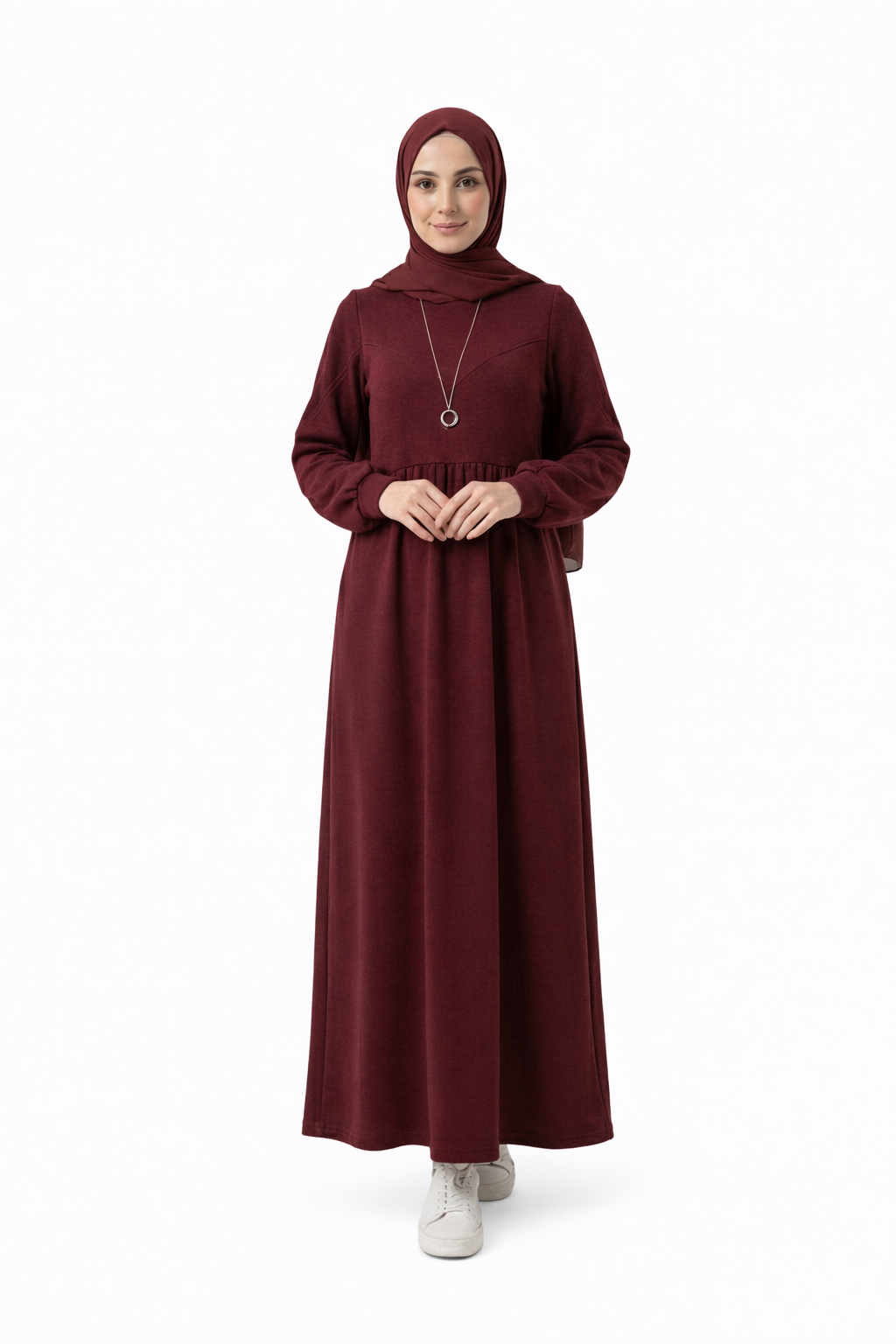 مودل ترتدي فستان طويل مودست باللون العنابي من ضي Dhai، تصميم واسع ومحتشم بأكمام طويلة مع حجاب مطابق، إطلالة أنيقة وبسيطة على خلفية بيضاء.
فستان برجاندي 
مودست فاشون
