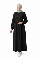 مودل ترتدي فستان طويل مودست باللون اسود من ضي Dhai، تصميم واسع ومحتشم بأكمام طويلة مع حجاب مطابق، إطلالة أنيقة وبسيطة على خلفية بيضاء.
فستان برجاندي 
مودست فاشون
دريس ميلتون
دريس ملتون