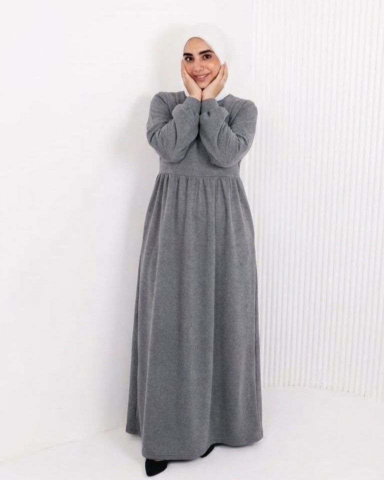 مودل ترتدي فستان طويل مودست باللون الفضي او الجراي من ضي Dhai، تصميم واسع ومحتشم بأكمام طويلة مع حجاب مطابق، إطلالة أنيقة وبسيطة على خلفية بيضاء.
فستان برجاندي 
مودست فاشون
دريس ميلتون
دريس ملتون